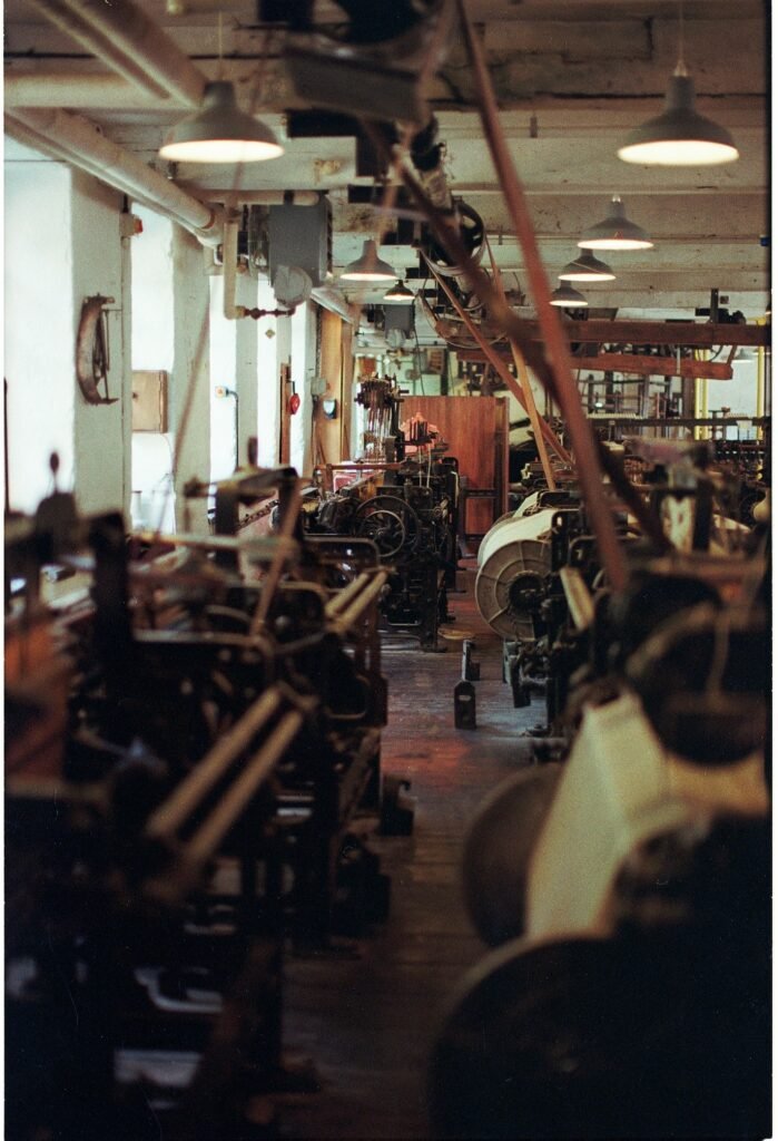 Interior of an industrial facility with rows of machinery and equipment in a factory production environment.