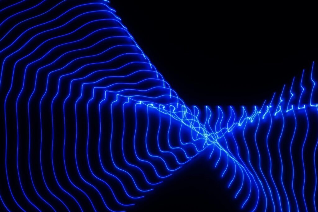 Abstract neon blue waveform lines converging and diverging against a dark background symbolizing technological advancement.