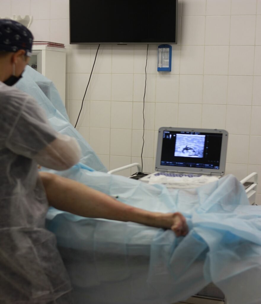 Medical professional performing a procedure using ultrasound equipment in a clinical setting