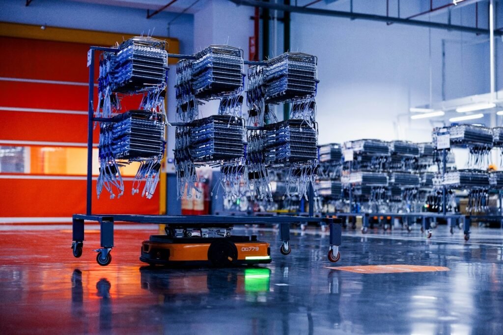 Autonomous mobile robot transporting inventory carts inside a modern warehouse, showcasing AI-powered logistics automation and smart material handling.